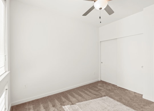 a living room with white walls and a ceiling fan at The Duo, Washington