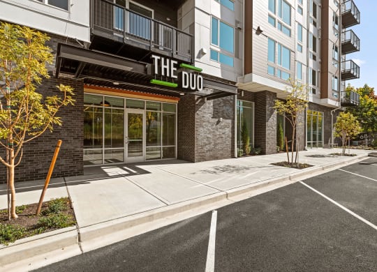a parking lot in front of a building with a sign on the side of it at The Duo, University Place