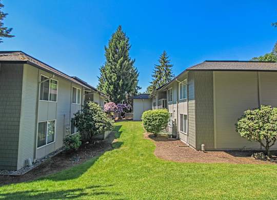 A sunny day at a residential complex with well-maintained lawns and trees.