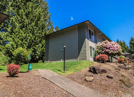 A house with a grey roof and a green lawn.