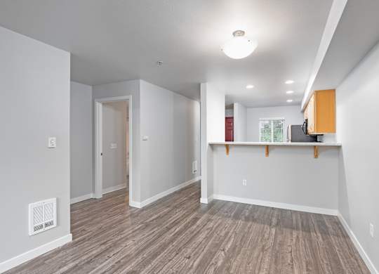 Open concept living and dining area with wood style flooring at 6Wood Flats Apartments in Lacey Washington