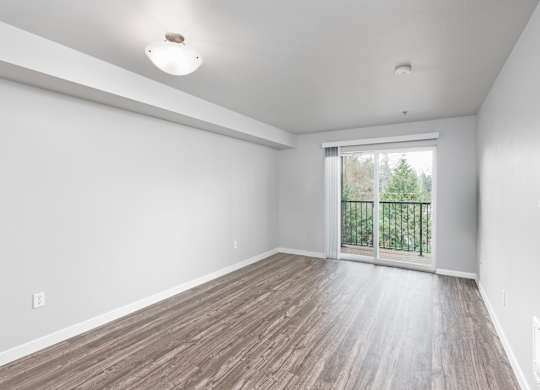 Large living room with sliding glass door in a 728 square foot 1 bedroom apartment at 6Wood Flats Apartments in Lacey WA