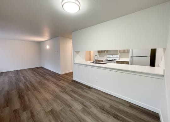 Open living room and dining area looks into the kitchen with white countertops.at The Trail, Washington, 98290