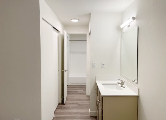 Full bathroom with a closet, a vanity sink, under sink cabinets, large mirror, and door to shower and toilet.at The Trail, Snohomish, WA 98290