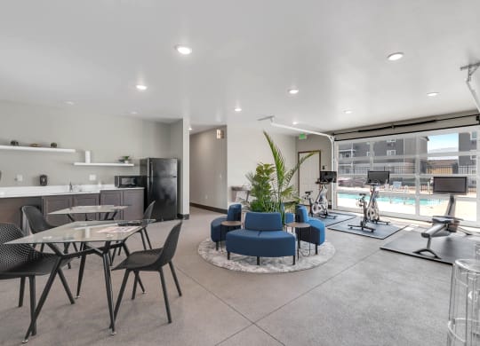 Spacious clubhouse with overhead doors and a pool view. A workout area to the right, and a kitchen and seating on the left. at Altitude, East Wenatchee, Washington