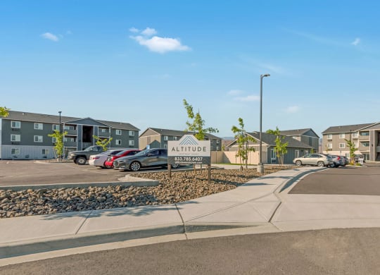 Exterior view of community buildings and parking lot. Bright blue sky and well-maintained landscaping. at Altitude, East Wenatchee