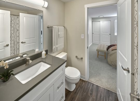 Ensuite bathroom with hard wood style flooring, toilet and vanity sinkat Edmonds Gateway, Bremerton.