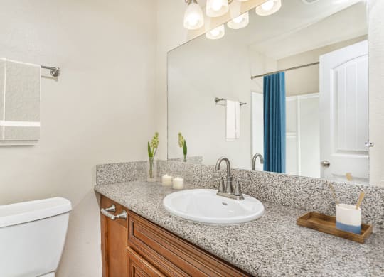 Apartment bathroom with towel rack, shower with tub and a large quartz countertop at Pacific Sands, San Diego, 92117