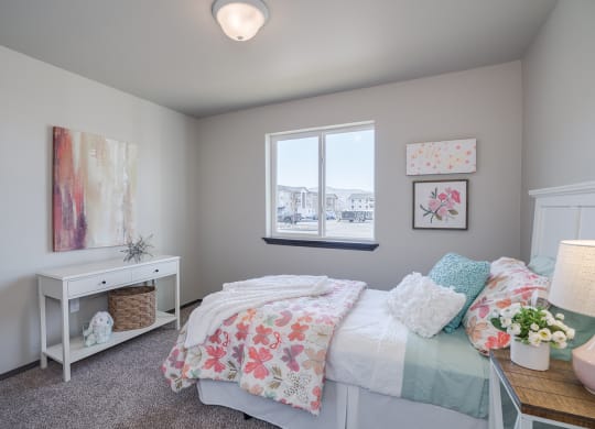 Bedroom with accent table, window and full size bed. at Altitude, East Wenatchee, Washington