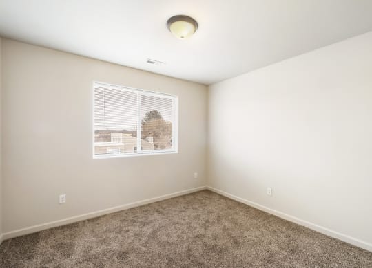 a bedroom with white walls, carpet, a large window and overhead lighting. at Pine Tree Park, Washington, 99337