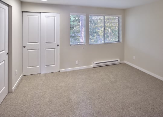 an empty room with carpet and a white door and window