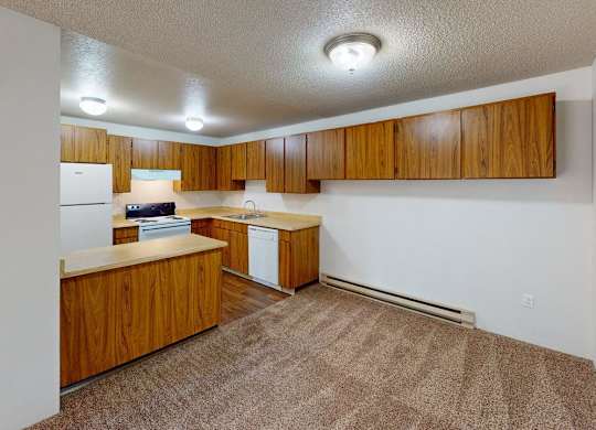 Spacious kitchen area at Heritage Grove Apartments Renton WA featuring timber-style cabinets, ample counter space, and overhead lighting.