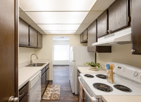 a kitchen with white appliances and wooden cabinets and a white stove and refrigerator