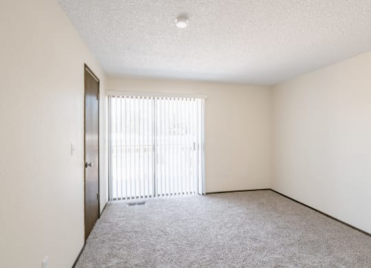 an empty living room with a sliding glass door