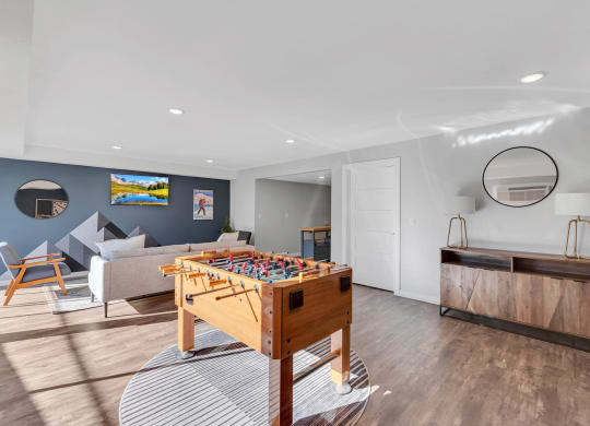 Clubhouse with wood floors, seating area, mounted TV, and a foosball table. at Castlerock, Wenatchee, WA 98801