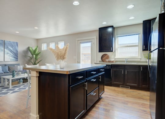 a kitchen with a center island and a living room  at Copper Pines, Bozeman, Montana