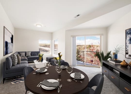 a dining area with a round table and chairs and a living room with a couch and wall art. at Shoreline Village, Richland Washington