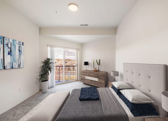 a bedroom with a queen-size bed and access to the private balcony.at Shoreline Village, Richland, WA