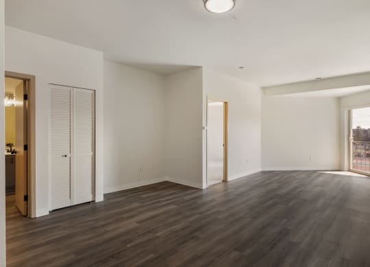 Open style living room with wood flooring, glass doors to private balcony.at Shoreline Village, Richland Washington