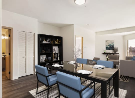 a dining room with a table, 4 blue chairs and the living room behind.at Shoreline Village, Richland, 99352
