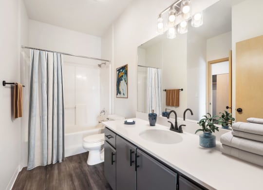 a bathroom with a large mirror and a shower with a curtain.at Shoreline Village, Washington, 99352