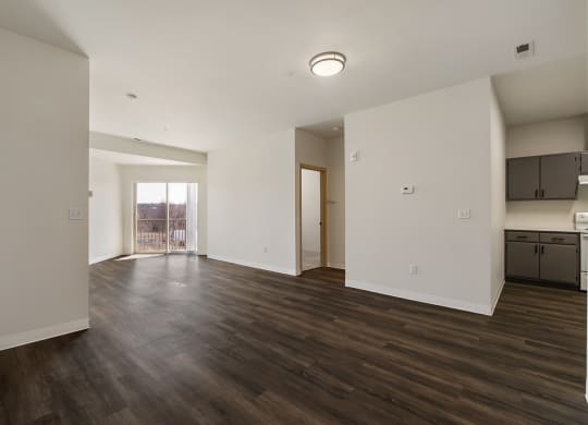 Large living area with wood flooring, bright white walls and sunny glass doors to balcony.at Shoreline Village, Richland Washington