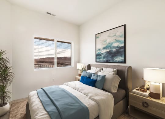A large bedroom with carpet, white walls, a sunny window and a bed.at Shoreline Village, Richland