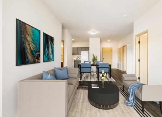 a living room with white walls and wood flooring. Staged with a gray couch, a table and wall art.at Shoreline Village, Richland Washington