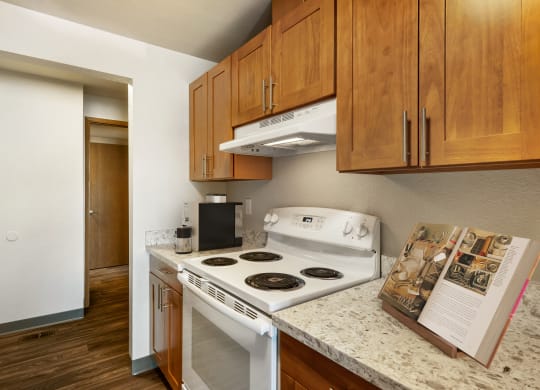 a kitchen with white appliances and wood cabinets  Kitchen at Cedarwood, Washington