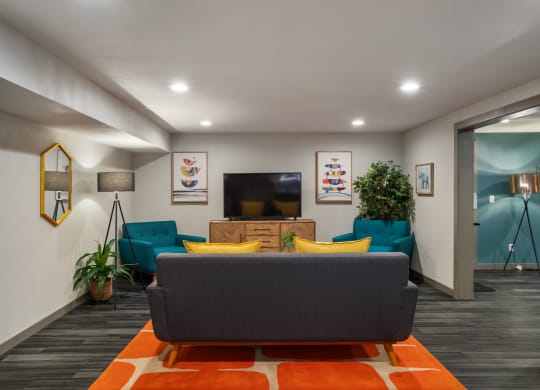 a living room with blue couches and yellow and orange pillows at Cedarwood, Wenatchee