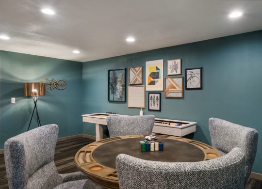 a game room with blue walls and a round table with three chairs at Cedarwood, Wenatchee, WA 98801