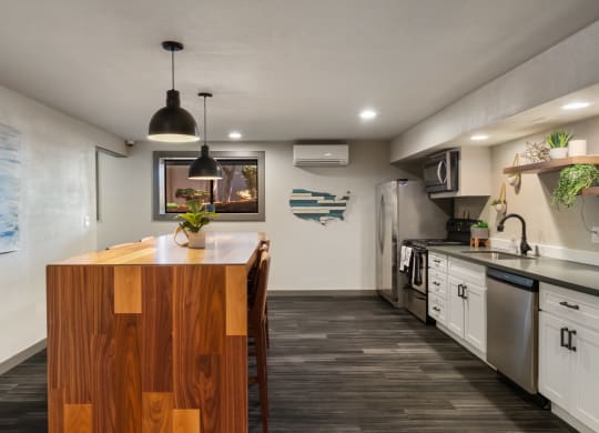 a kitchen with white cabinets and a wooden island with a vase of flowers on it at Cedarwood, Wenatchee, WA