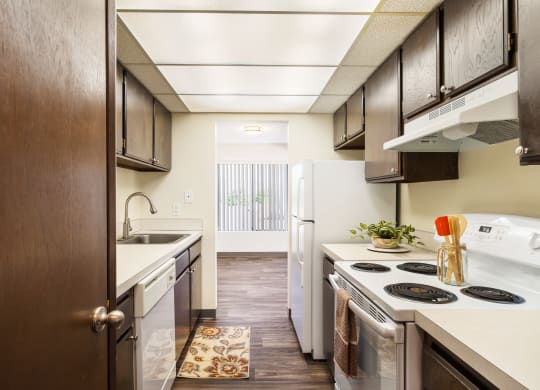 kitchen with dark wood cabinets and open to dining with window at Castlerock, Washington, 98801
