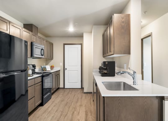 a kitchen with wooden cabinets and a white counter top  at Altitude, East Wenatchee, WA