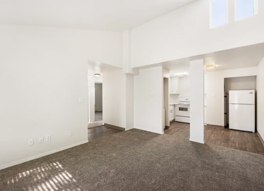 the living room and kitchen of an apartment with white walls and wood flooring at Park View Apartments, Wenatchee, WA