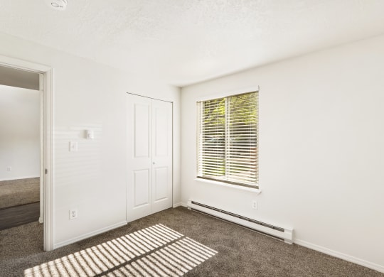 the living room of an apartment with carpet and a window  at Park View Apartments, Wenatchee, Washington