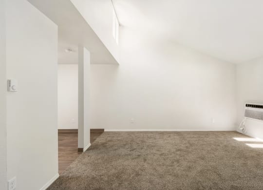 an empty living room with white walls and a carpet at Park View Apartments, Wenatchee, 98801