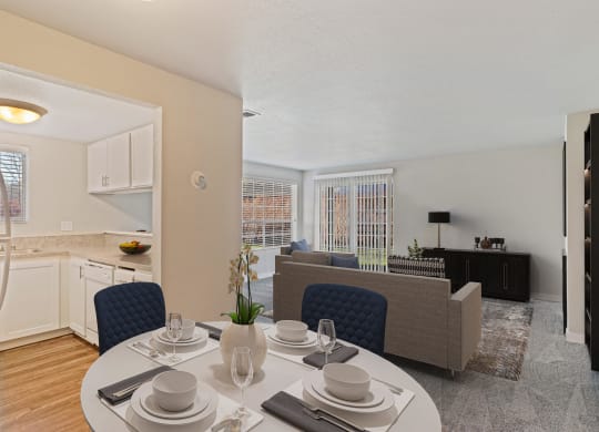 Dining area with view of kitchen leads into carpeted living room, with large window and sliding glass doors.at Capitol Crossing, Olympia, WA