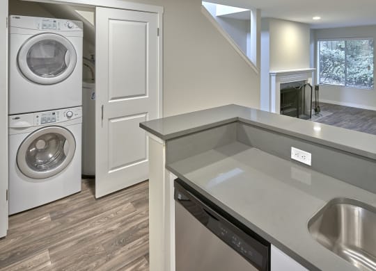 Kitchen looking into double door closet with stacked washer and dryer.at Edmonds Gateway, Edmonds, 98026