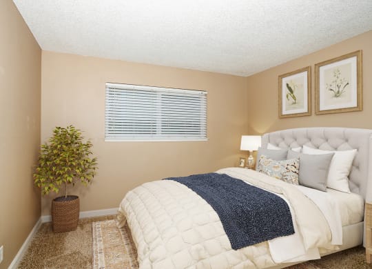 a bedroom with a bed and a potted plant
