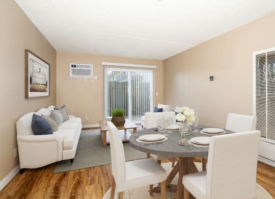 a living room and dining room with a table and chairs