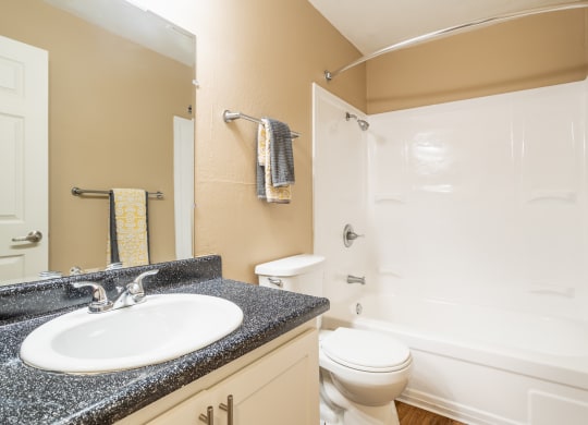 a bathroom with a sink toilet and full bathtub at Ella 1711 Apartments, Woodland California