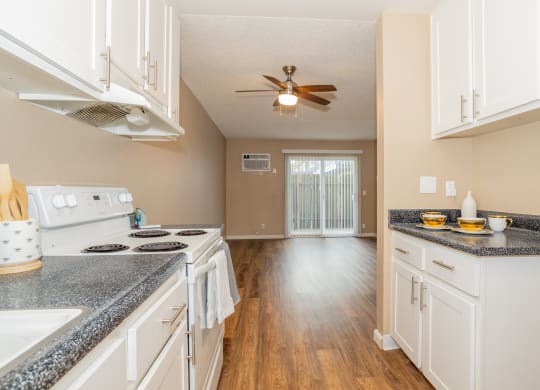 an empty kitchen with white cabinets and a ceiling fan at Ella 1711 Apartments, Woodland, CA 95695