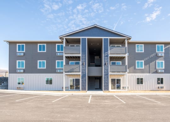 Exterior image of building. Blue, grey, and white siding and outdoor access to units. at Altitude, East Wenatchee