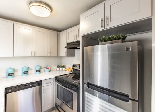 Kitchen in community lounge with stainless steel appliances and new white cabinets at The Lakes Apartments, Moses Lake, WA.