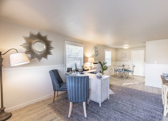 Property office showing comfortable chairs, desk, floor lamp and side table at The Lakes Apartments, Moses Lake, WA.