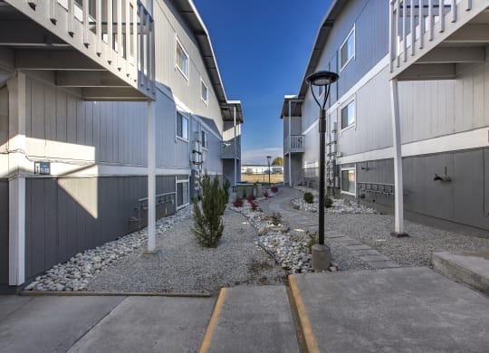 Exterior view of manicured rock path between buildings at The Lakes Apartments, Moses Lake, WA.