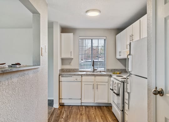 an open kitchen with white appliances and white cabinets