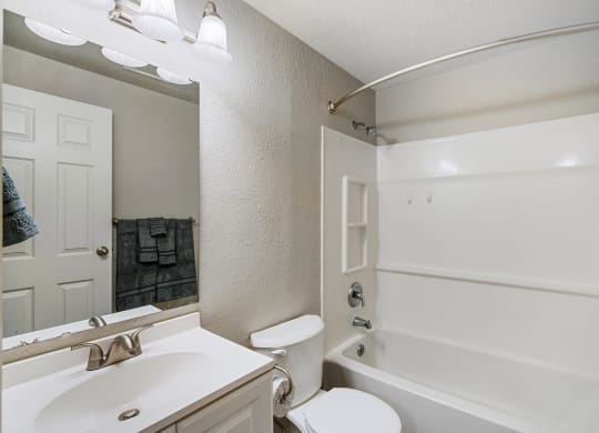 Bathroom with white counters, a mirror, sink, toilet, shower, and bath tub from left to right.at Capitol Crossing, Olympia, WA 98501