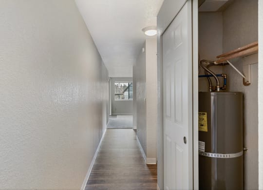 a hallway with a white door and a stainless steel water tank